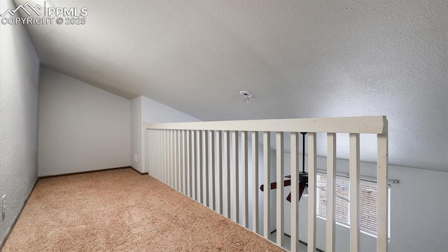 hall with carpet and lofted ceiling