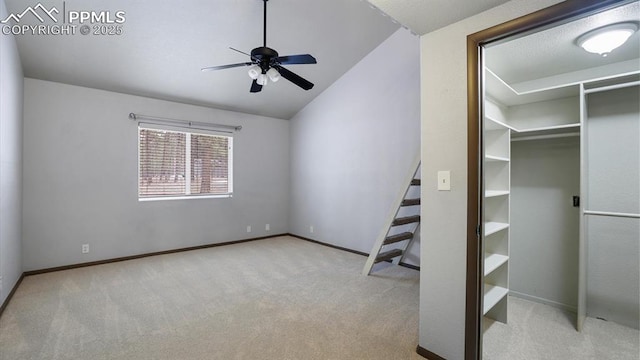 unfurnished bedroom with ceiling fan, light carpet, and lofted ceiling