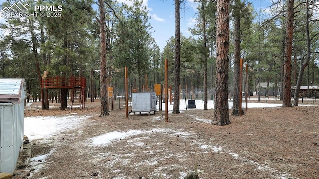 snowy yard featuring a playground