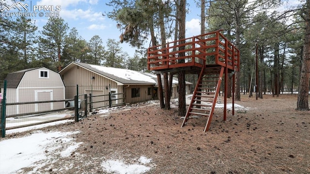 exterior space featuring a garage, an outdoor structure, and a wooden deck