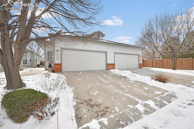 snow covered property with a garage