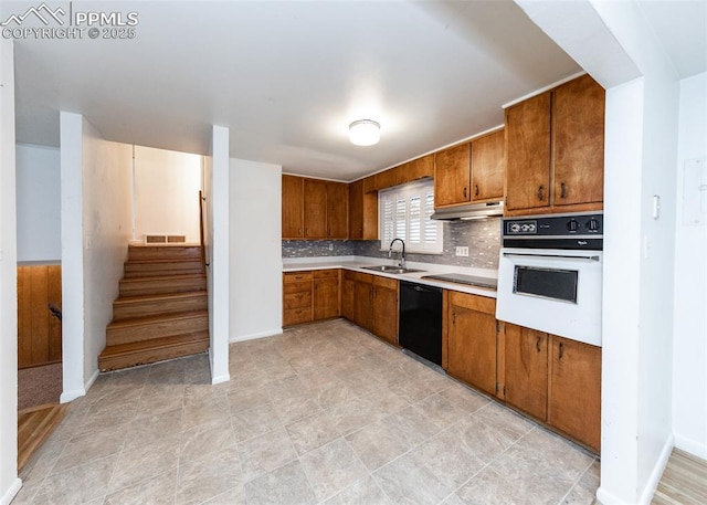 kitchen featuring black appliances, decorative backsplash, and sink