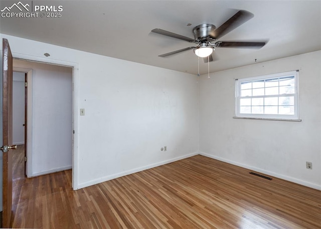 spare room with ceiling fan and hardwood / wood-style flooring