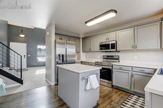 kitchen featuring pendant lighting, a center island, stainless steel appliances, and gray cabinets