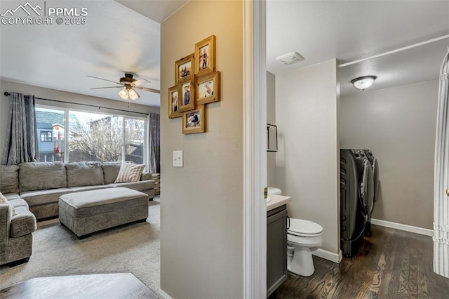 bathroom featuring hardwood / wood-style floors, vanity, ceiling fan, toilet, and washing machine and clothes dryer