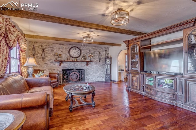 living room with beam ceiling, wood-type flooring, and a fireplace