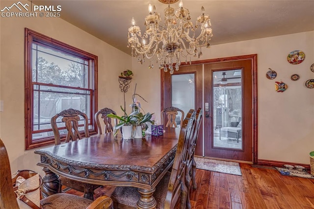 dining space featuring french doors, wood-type flooring, and a notable chandelier