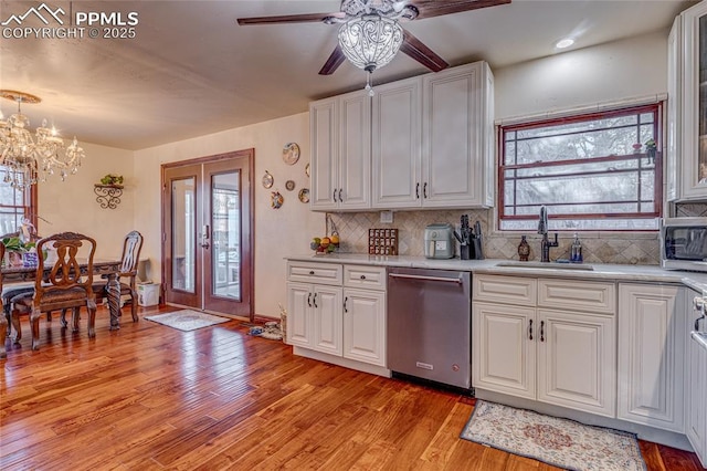 kitchen featuring white cabinetry, dishwasher, sink, backsplash, and light hardwood / wood-style floors