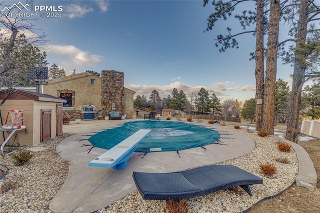 view of pool featuring a patio and a diving board