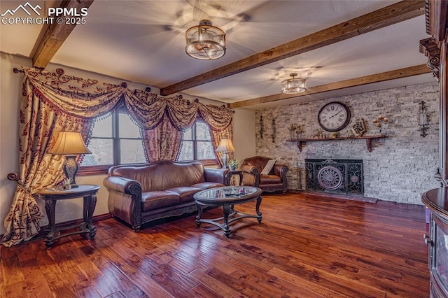 living room with hardwood / wood-style floors, beamed ceiling, and a brick fireplace