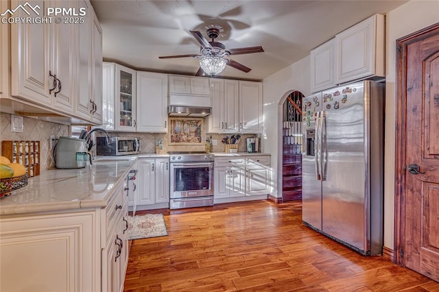 kitchen featuring backsplash, white cabinets, and appliances with stainless steel finishes