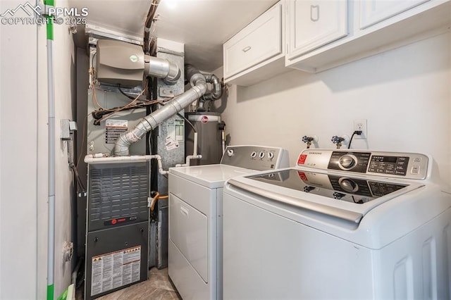 washroom featuring cabinets, gas water heater, and washer and clothes dryer