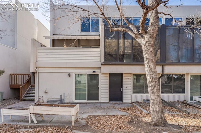 rear view of house featuring a patio area and a balcony