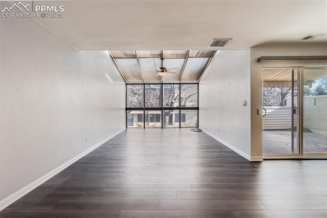 spare room with ceiling fan, expansive windows, and dark wood-type flooring