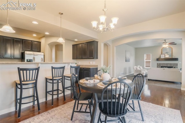 dining area featuring hardwood / wood-style flooring and ceiling fan with notable chandelier