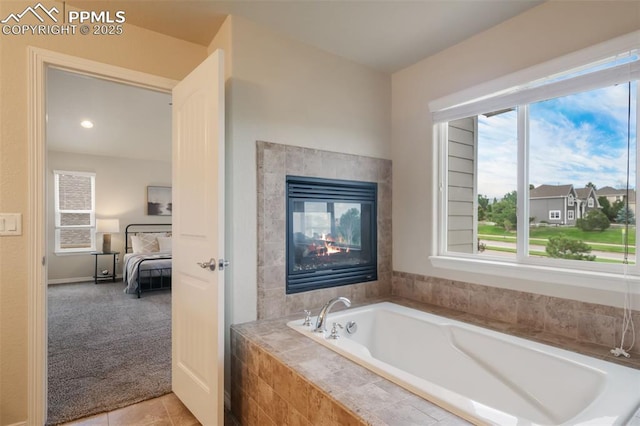 bathroom featuring a multi sided fireplace, a relaxing tiled tub, and tile patterned floors