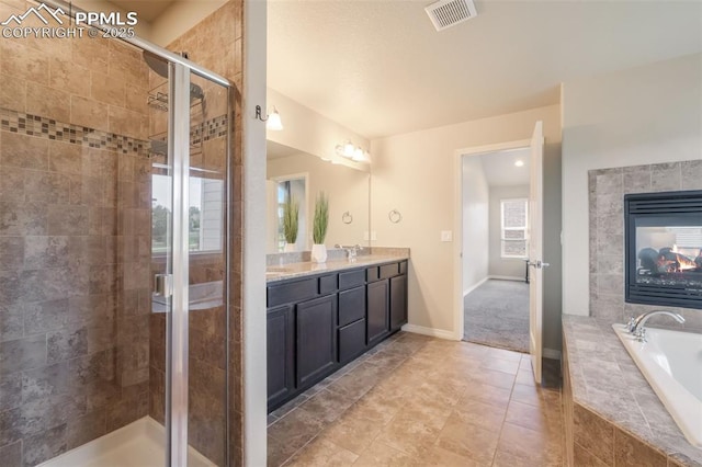 bathroom with shower with separate bathtub, vanity, and a healthy amount of sunlight