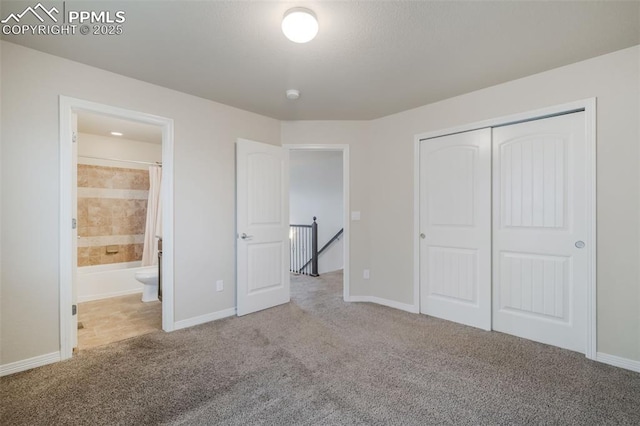 unfurnished bedroom featuring connected bathroom, carpet floors, and a closet