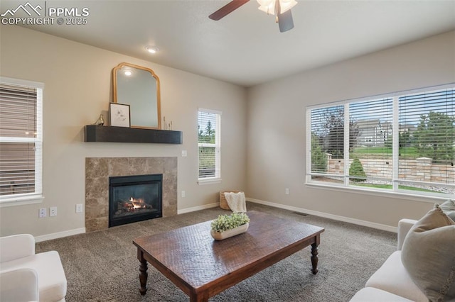 carpeted living room with a fireplace and ceiling fan