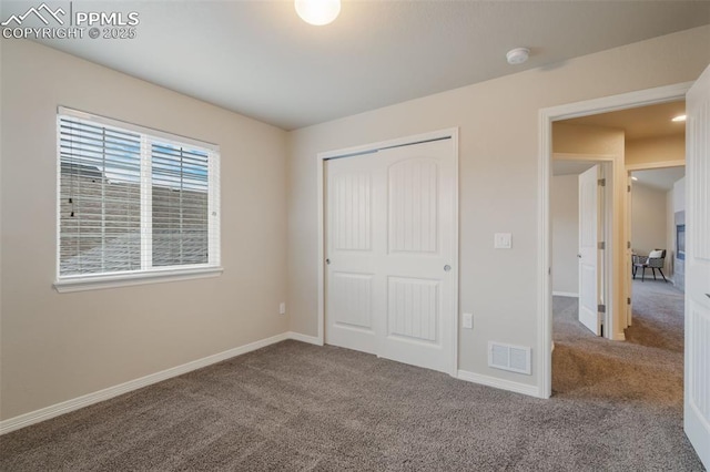 unfurnished bedroom with carpet flooring and a closet