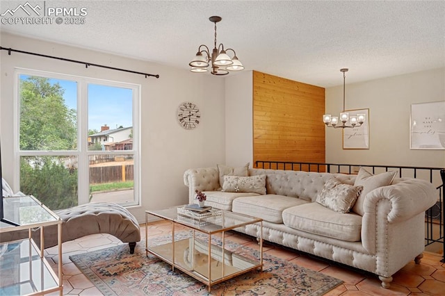 tiled living room with wooden walls, a chandelier, and a textured ceiling