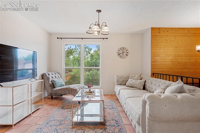 living room with a chandelier, light tile patterned floors, a textured ceiling, and wooden walls