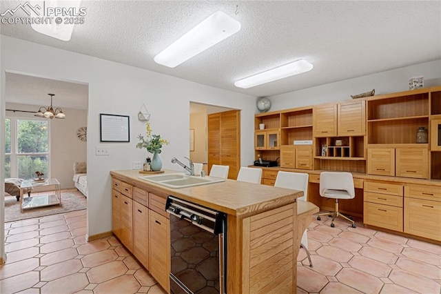 kitchen featuring light brown cabinets, black dishwasher, hanging light fixtures, and sink