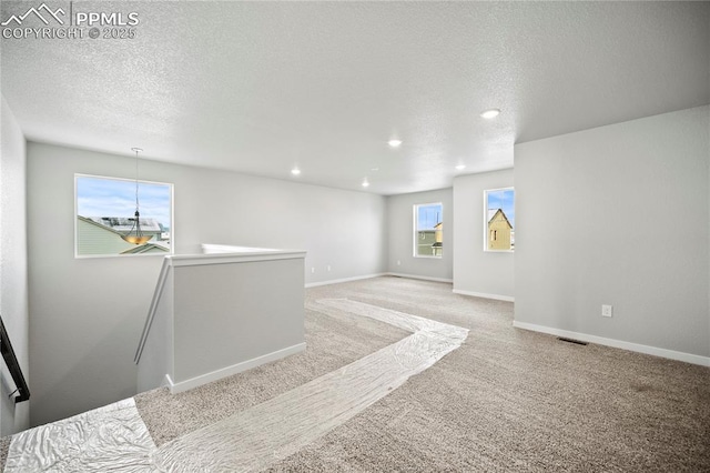 empty room featuring carpet and a textured ceiling