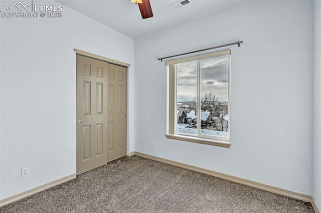 unfurnished bedroom featuring ceiling fan, multiple windows, a closet, and carpet