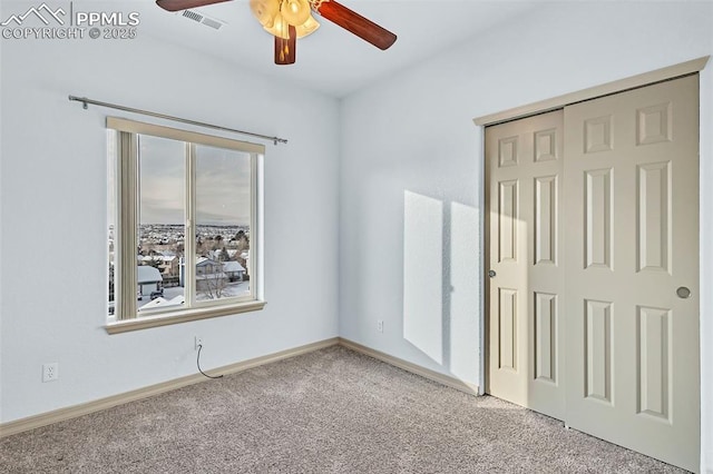 unfurnished bedroom featuring ceiling fan, multiple windows, a closet, and light carpet