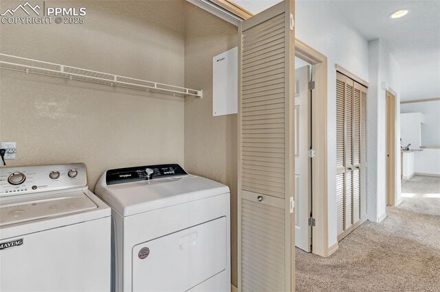 clothes washing area with washer and dryer and light carpet