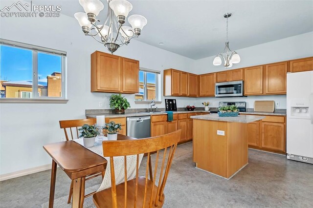 kitchen featuring decorative light fixtures, a kitchen island, appliances with stainless steel finishes, and a notable chandelier