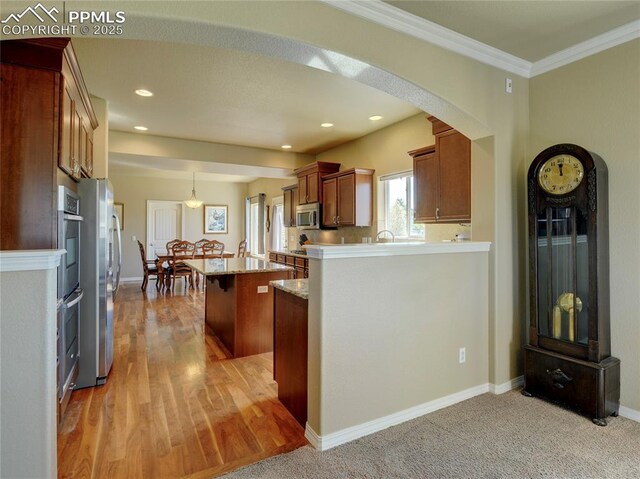 1235 Woodmoor Acres Dr, Monument, CO 80132 - kitchen featuring a kitchen bar, ornamental molding, stainless steel appliances, decorative light fixtures, and a kitchen island