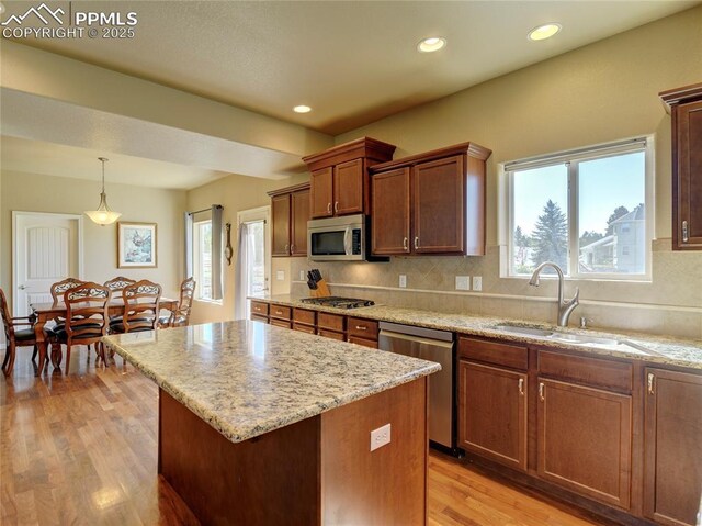 1235 Woodmoor Acres Dr, Monument, CO 80132 - kitchen featuring sink, pendant lighting, decorative backsplash, a kitchen island, and appliances with stainless steel finishes