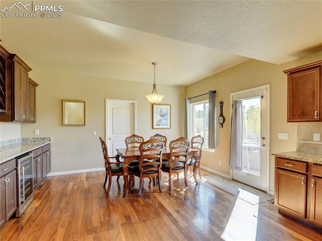 1235 Woodmoor Acres Dr, Monument, CO 80132 - dining space with hardwood / wood-style floors, a textured ceiling, and wine cooler