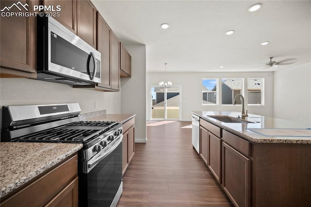 kitchen featuring pendant lighting, sink, appliances with stainless steel finishes, dark hardwood / wood-style flooring, and ceiling fan with notable chandelier