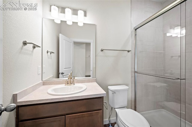 bathroom featuring toilet, vanity, and a shower with door