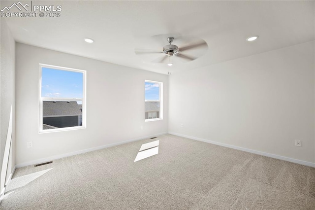 carpeted spare room with ceiling fan and plenty of natural light