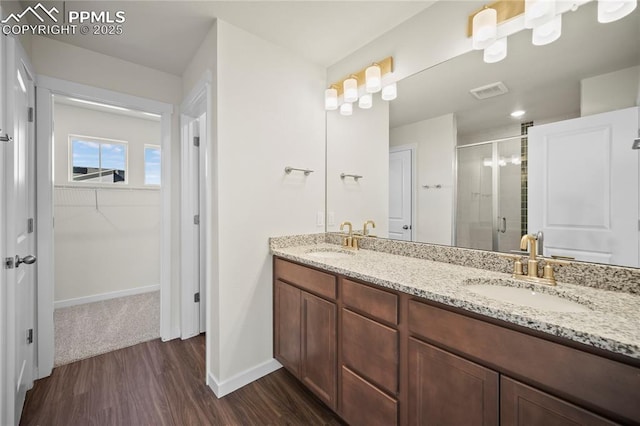 bathroom featuring vanity, wood-type flooring, and an enclosed shower