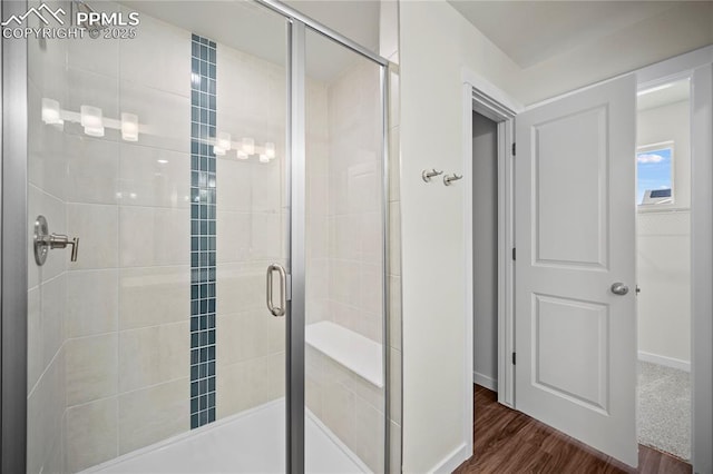 bathroom featuring hardwood / wood-style flooring and walk in shower