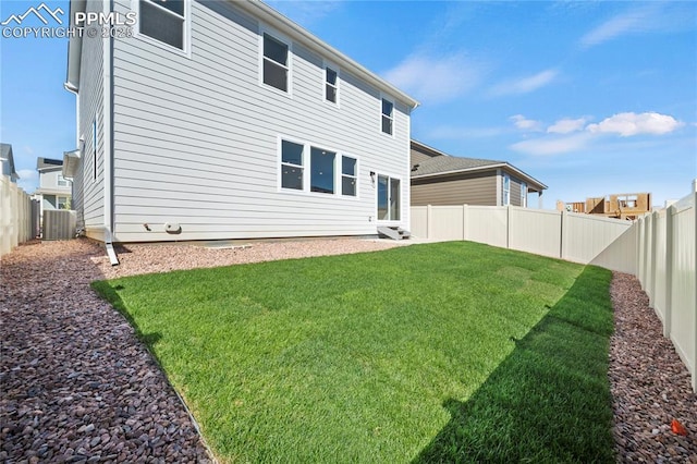 back of house with cooling unit and a lawn