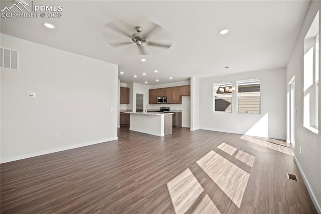 unfurnished living room with dark hardwood / wood-style flooring and ceiling fan with notable chandelier