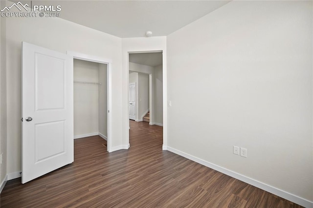 unfurnished bedroom with dark wood-type flooring and a closet