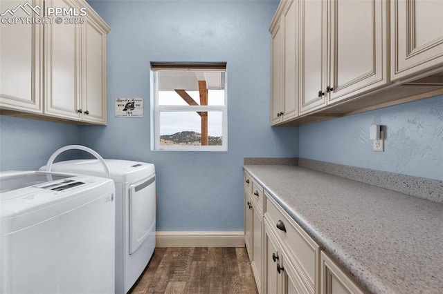 laundry area with washer and clothes dryer, dark hardwood / wood-style floors, and cabinets