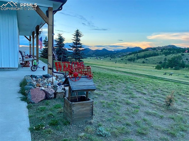 yard at dusk featuring a mountain view