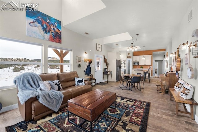 living room with a chandelier and light hardwood / wood-style flooring