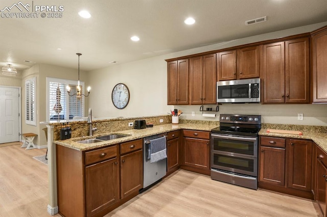 kitchen with sink, hanging light fixtures, stainless steel appliances, kitchen peninsula, and a chandelier