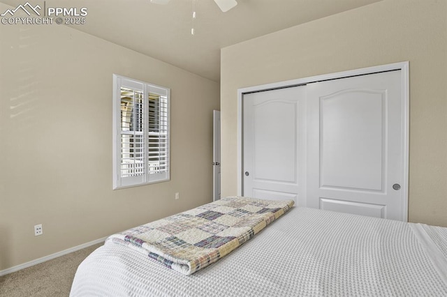 carpeted bedroom featuring ceiling fan and a closet