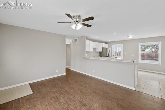 unfurnished living room with ceiling fan and dark wood-type flooring