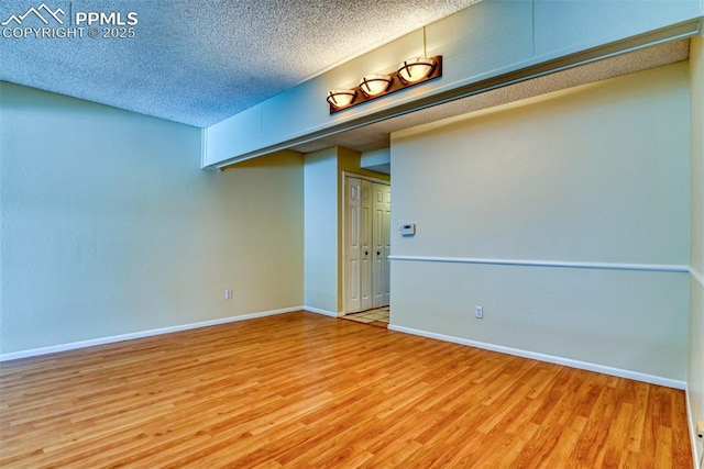 empty room with hardwood / wood-style floors and a textured ceiling